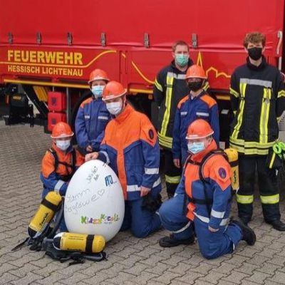 Kinder in Feuerwehruniformen vor einem Feuerwehrauto